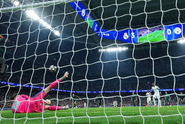 Manchester City's Italian goalkeeper #25 Gianluigi Donnarumma (L) saves a penatly kick by Real Madrid's Brazilian forward #07 Vinicius Junior during the UEFA Champions League last 16 first leg football match between Real Madrid CF and Manchester City at Santiago Bernabeu Stadium in Madrid on March 11, 2026. (Photo by Thomas COEX / AFP)
