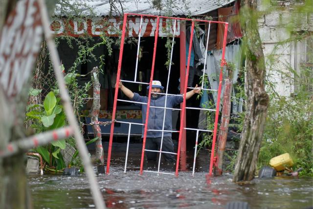 A man gestures during a flood in Agua Azul, Tucuman province, Argentina on March 11, 2026. (Photo by Walter MONTEROS / AFP)