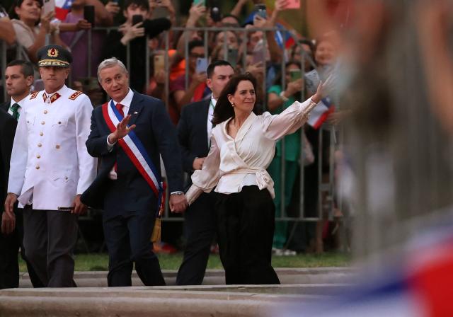 Chile's new President Jose Antonio Kast and his wife Maria Pia Adriasola wave to supporters as they arrive at La Moneda palace after his inauguration in Santiago on March 11, 2026. Chile's most right-wing president in over three decades, Jose Antonio Kast, takes office on March 11, 2026, on a promise to tackle surging rates of violent crime and carry out mass migrant deportations. (Photo by Javier TORRES / AFP)