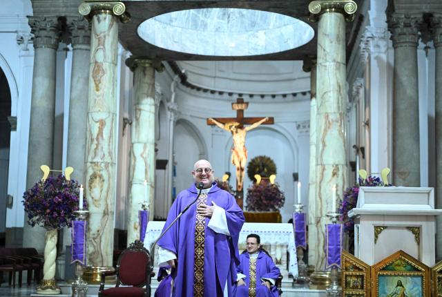 Guilherme Peixoto, a priest and DJ, gives the communion to a woman during a mass at Metropolitan Cathedral in Guatemala City on March 11, 2026. The Portuguese Catholic priest and DJ Guilherme Peixoto is visiting Guatemala for a concert on March 12. (Photo by JOHAN ORDONEZ / AFP)