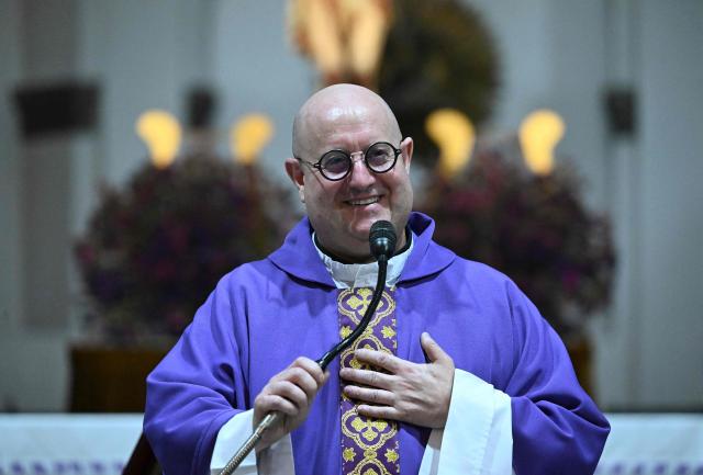 Guilherme Peixoto, a priest and DJ, gives the communion to a woman during a mass at Metropolitan Cathedral in Guatemala City on March 11, 2026. The Portuguese Catholic priest and DJ Guilherme Peixoto is visiting Guatemala for a concert on March 12. (Photo by JOHAN ORDONEZ / AFP)