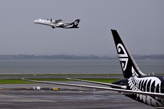 (FILES) A photo taken on June 10, 2025 shows Air New Zealand passenger planes at New Zealand's Auckland International Airport. New Zealand's national airline said March 12, 2026, it would cancel 1,100 flights over the next two months, pointing to the impact of the war in the Middle East. (Photo by William WEST / AFP)