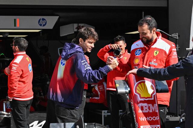 Ferrari's Monegasque driver Charles Leclerc (C) greets Ferrari team members at the Shanghai International Circuit ahead of the Formula One Chinese Grand Prix in Shanghai on March 12, 2026. (Photo by Hector RETAMAL / AFP)