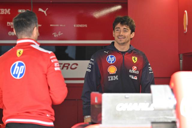 Ferrari's Monegasque driver Charles Leclerc (R) greets a Ferrari team member at the Shanghai International Circuit ahead of the Formula One Chinese Grand Prix in Shanghai on March 12, 2026. (Photo by Hector RETAMAL / AFP)