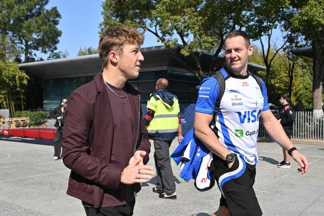 Racing Bulls' New Zealand driver Liam Lawson (L) arrives to the paddock at the Shanghai International Circuit ahead of the Formula One Chinese Grand Prix in Shanghai on March 12, 2026. (Photo by Hector RETAMAL / AFP)
