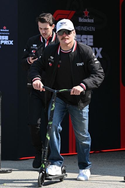 Cadillac's Finnish driver Valtteri Bottas rides a scooter in the paddock at the Shanghai International Circuit ahead of the Formula One Chinese Grand Prix in Shanghai on March 12, 2026. (Photo by Hector RETAMAL / AFP)