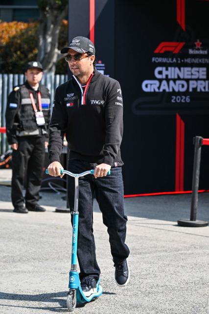 Cadillac's Mexican driver Sergio Perez rides a scooter in the paddock at the Shanghai International Circuit ahead of the Formula One Chinese Grand Prix in Shanghai on March 12, 2026. (Photo by Hector RETAMAL / AFP)