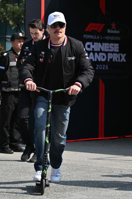 Cadillac's Finnish driver Valtteri Bottas rides a scooter in the paddock at the Shanghai International Circuit ahead of the Formula One Chinese Grand Prix in Shanghai on March 12, 2026. (Photo by Hector RETAMAL / AFP)