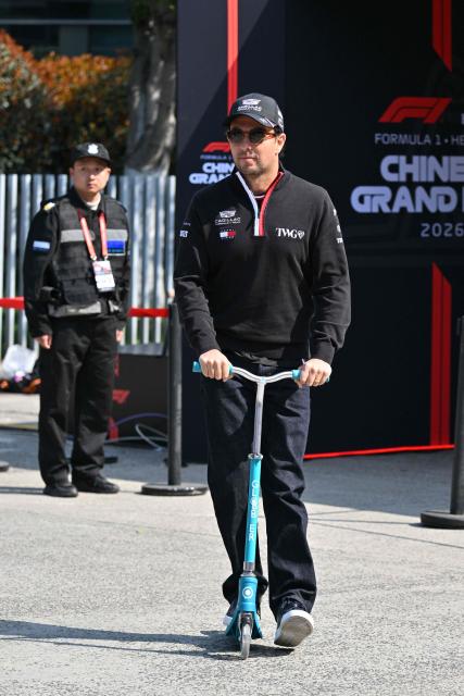 Cadillac's Mexican driver Sergio Perez rides a scooter in the paddock at the Shanghai International Circuit ahead of the Formula One Chinese Grand Prix in Shanghai on March 12, 2026. (Photo by Hector RETAMAL / AFP)
