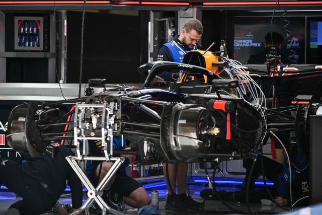 Red Bull Racing's Dutch driver Max Verstappen's team members work on the car in the garage at the Shanghai International Circuit ahead of the Formula One Chinese Grand Prix in Shanghai on March 12, 2026. (Photo by Hector RETAMAL / AFP)