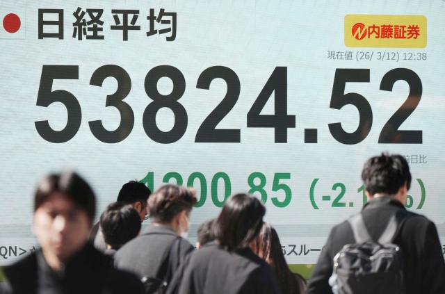 An electronic quotation boards displays the Nikkei Stock Average on the Tokyo Stock Exchange along a street in Tokyo on March 12, 2026. (Photo by Kazuhiro NOGI / AFP)