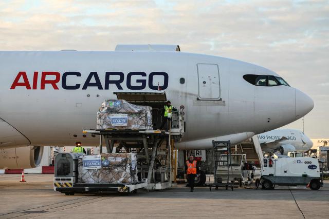 Workers load humanitarian aid into an aircraft destined for Lebanon at Roissy-Charles de Gaulle Airport on the outskirts of Paris on March 12, 2026. France is preparing to triple its humanitarian support to Lebanon by sending 60 tons of aid on March 12, 2026 for refugees leaving the south of the country, where Israel is conducting military operations against the pro-Iranian Hezbollah, the French foreign minister announced on March 11, 2026. (Photo by Dimitar DILKOFF / AFP)