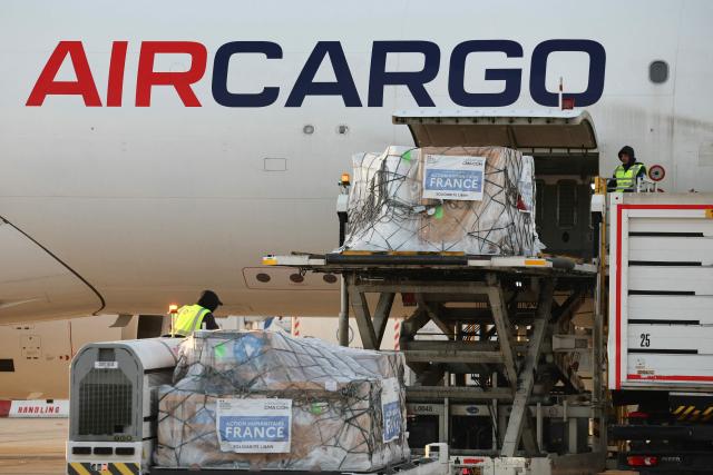 Workers load humanitarian aid into an aircraft destined for Lebanon at Roissy-Charles de Gaulle Airport on the outskirts of Paris on March 12, 2026. France is preparing to triple its humanitarian support to Lebanon by sending 60 tons of aid on March 12, 2026 for refugees leaving the south of the country, where Israel is conducting military operations against the pro-Iranian Hezbollah, the French foreign minister announced on March 11, 2026. (Photo by Dimitar DILKOFF / AFP)