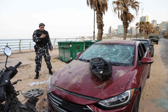 A policeman inspects a damaged car at the site of an Israeli airstrike on the seaside area of Ramlet al-Bayda in Beirut early on March 12, 2026. Lebanon said an Israeli strike on central Beirut's seafront killed at least seven people early on March 12, another attack in the heart of the capital as Iran-backed Hezbollah launched more missiles at Israel. (Photo by Anwar AMRO / AFP)