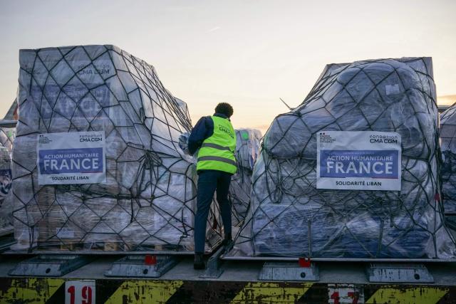 Workers load humanitarian aid into an aircraft destined for Lebanon at Roissy-Charles de Gaulle Airport on the outskirts of Paris on March 12, 2026. France is preparing to triple its humanitarian support to Lebanon by sending 60 tons of aid on March 12, 2026 for refugees leaving the south of the country, where Israel is conducting military operations against the pro-Iranian Hezbollah, the French foreign minister announced on March 11, 2026. (Photo by Dimitar DILKOFF / AFP)
