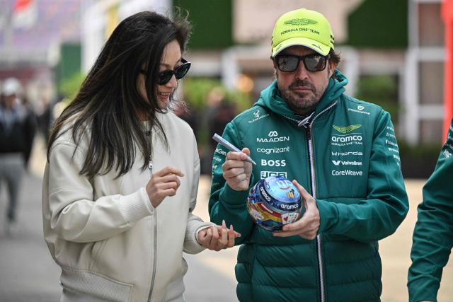 Aston Martin's Spanish driver Fernando Alonso signs an autograph for a fan at the paddock ahead of the Formula One Chinese Grand Prix at the Shanghai International Circuit in Shanghai on March 12, 2026. (Photo by Jade GAO / AFP)