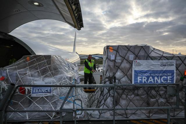 Workers load humanitarian aid into an aircraft destined for Lebanon at Roissy-Charles de Gaulle Airport on the outskirts of Paris on March 12, 2026. France is preparing to triple its humanitarian support to Lebanon by sending 60 tons of aid on March 12, 2026 for refugees leaving the south of the country, where Israel is conducting military operations against the pro-Iranian Hezbollah, the French foreign minister announced on March 11, 2026. (Photo by Dimitar DILKOFF / AFP)