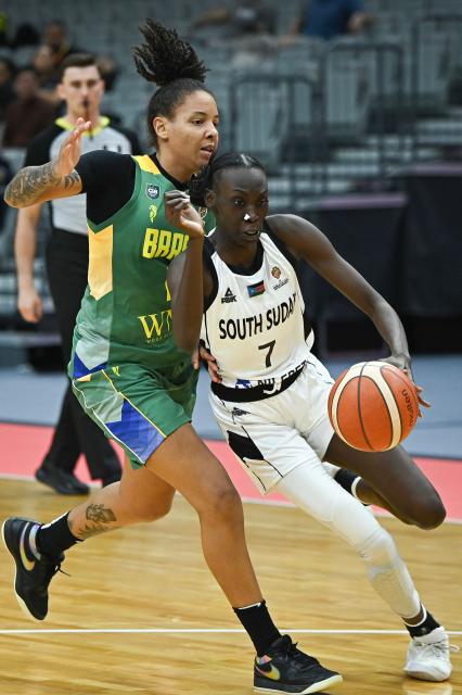 South Sudan's Nyamer Diew (R) dribbles past Brazil's Emanuely Oliveira during the FIBA Women's Basketball World Cup 2026 qualifying tournament match between Brazil and South Sudan in Wuhan, in China's central Hubei province, on March 12, 2026. (Photo by CN-STR / AFP) / China OUT