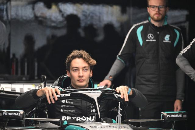 Mercedes' British driver George Russell poses for photos in his car during preparations ahead of the Formula One Chinese Grand Prix at the Shanghai International Circuit in Shanghai on March 12, 2026. (Photo by GREG BAKER / AFP)