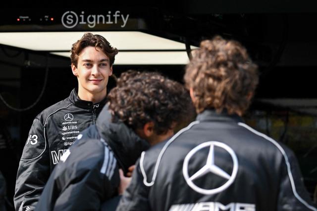 Mercedes' British driver George Russell (L) stands outside a garage ahead of the Formula One Chinese Grand Prix at the Shanghai International Circuit in Shanghai on March 12, 2026. (Photo by Hector RETAMAL / AFP)