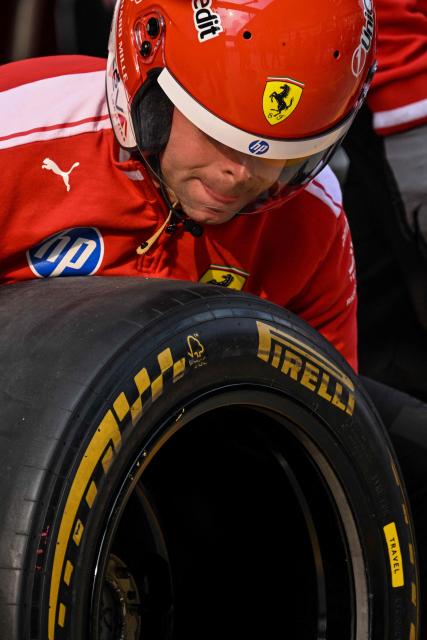 A Ferrari team members practices a pit stop with the car of Ferrari's Monegasque driver Charles Leclerc ahead of the Formula One Chinese Grand Prix at the Shanghai International Circuit in Shanghai on March 12, 2026. (Photo by Hector RETAMAL / AFP)