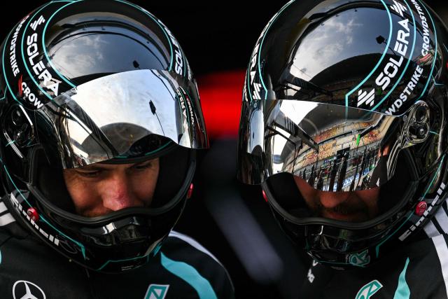 Mercedes team members practice a pit stop with the car of Mercedes' British driver George Russell ahead of the Formula One Chinese Grand Prix at the Shanghai International Circuit in Shanghai on March 12, 2026. (Photo by Hector RETAMAL / AFP)