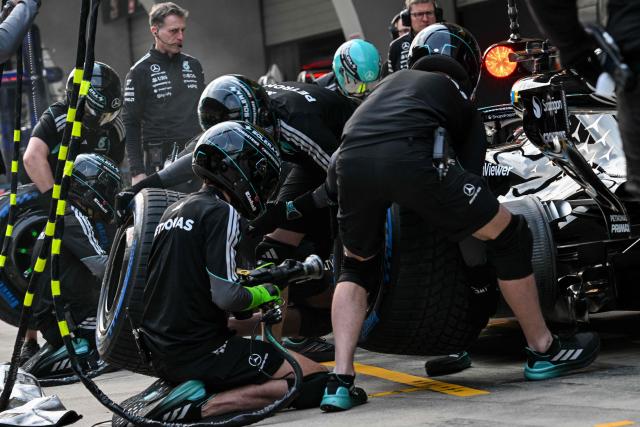 Mercedes team members practice a pit stop with the car of Mercedes' British driver George Russell ahead of the Formula One Chinese Grand Prix at the Shanghai International Circuit in Shanghai on March 12, 2026. (Photo by Hector RETAMAL / AFP)