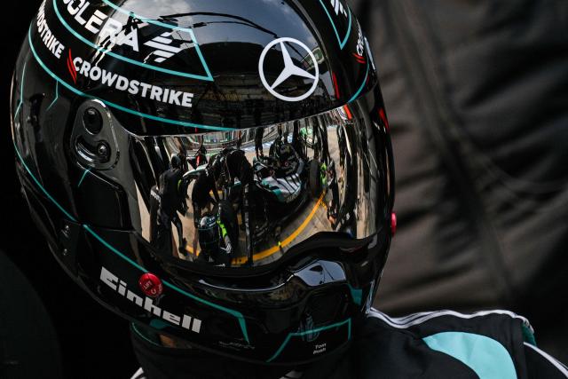 Mercedes team members practice a pit stop with the car of Mercedes' British driver George Russell ahead of the Formula One Chinese Grand Prix at the Shanghai International Circuit in Shanghai on March 12, 2026. (Photo by Hector RETAMAL / AFP)