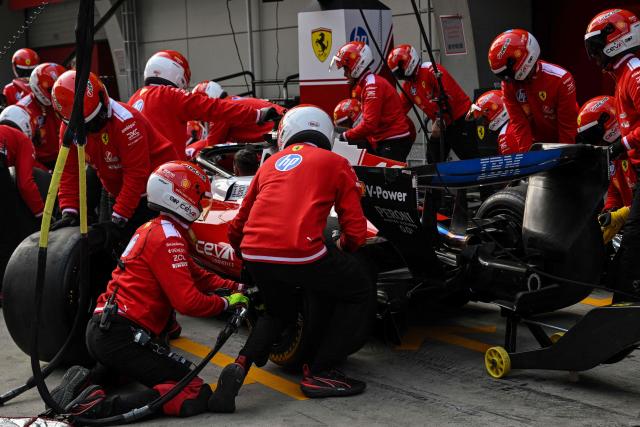 Ferrari's team members practice a pit stop with the car of Ferrari's Monegasque driver Charles Leclerc ahead of the Formula One Chinese Grand Prix at the Shanghai International Circuit in Shanghai on March 12, 2026. (Photo by Hector RETAMAL / AFP)