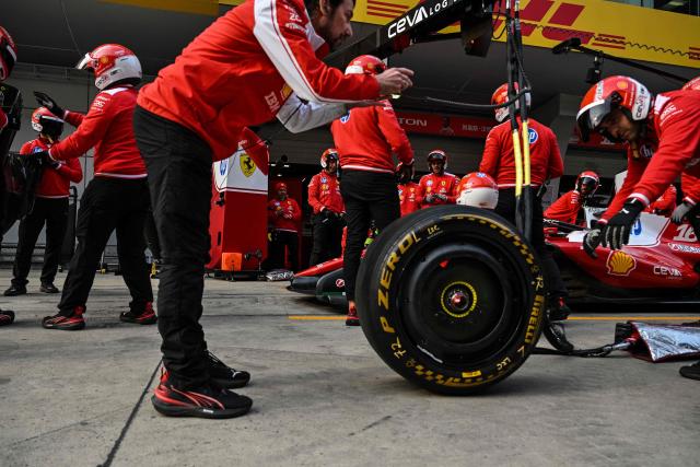 Ferrari's team members practice a pit stop with the car of Ferrari's Monegasque driver Charles Leclerc ahead of the Formula One Chinese Grand Prix at the Shanghai International Circuit in Shanghai on March 12, 2026. (Photo by Hector RETAMAL / AFP)