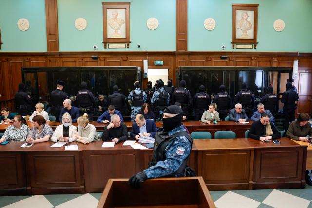 Defendants accused of involvement in the 2024 Crocus City Hall music venue gun attack that killed 149 people, sit in glass boxes prior to the announcement of their verdicts at a court in Moscow on March 12, 2026. Russia on March 12, 2026 sentenced 15 men -- including four gunmen -- to life in prison over the Crocus concert hall attack, the deadliest onslaught in Russia in more than two decades. (Photo by TATYANA MAKEYEVA / AFP)