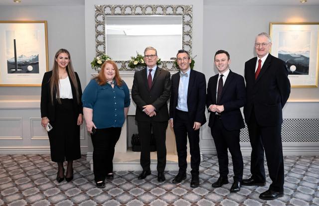 Britain's Prime Minister Keir Starmer poses with Alliance MP Sorcha Eastwood (L), Alliance party leader Naomi Long (2L), Northern Ireland's Minister of Agriculture, Environment, and Rural Affairs Andrew Muir (3R) and Secretary of State for Northern Ireland Hilary Benn (R) during their meeting at a hotel in suburban Belfast, Northern Ireland, on March 12, 2026. (Photo by Mark Marlow / POOL / AFP)