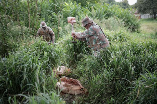 Soldiers of the South African National Defence Force (SANDF) destroy bags of soil, intended to be sifted for gold by artisanal miners, during a patrol in Randfontein on MArch 12, 2026. South Africa deployed soldiers for a year to provinces struggling to quell rampant crime and illegal mining, according to a mission plan presented to parliament on March 4, 2026.
President Cyril Ramaphosa announced the deployment last month, calling organised crime the "most immediate threat" to South Africa's democracy and economic development. (Photo by EMMANUEL CROSET / AFP)