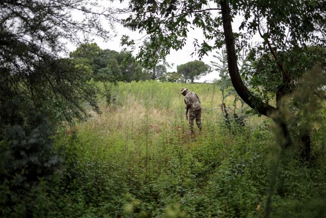 A South African National Defence Force (SANDF) soldier inspects a hole in the ground used by artisanal miners, during a patrol in Randfontein on March 12, 2026. South Africa deployed soldiers for a year to provinces struggling to quell rampant crime and illegal mining, according to a mission plan presented to parliament on March 4, 2026.
President Cyril Ramaphosa announced the deployment last month, calling organised crime the "most immediate threat" to South Africa's democracy and economic development. (Photo by EMMANUEL CROSET / AFP)