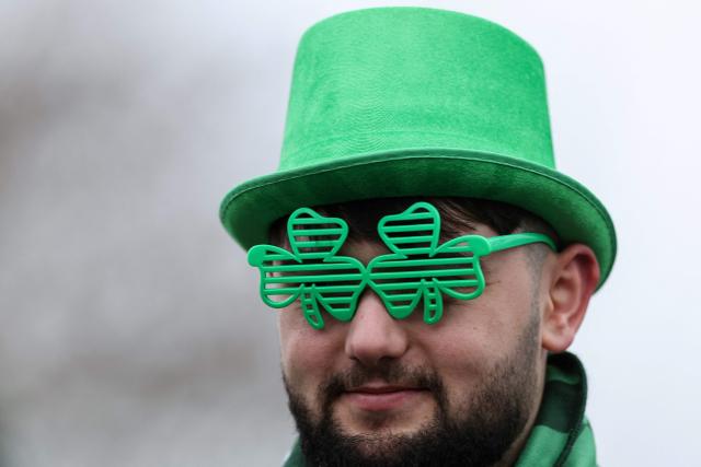 A racegoer marks 'St Patrick's Thursday' with an Irish them, on the third day of the Cheltenham Festival at Cheltenham Racecourse, in Cheltenham, western England on March 12, 2026. (Photo by Adrian Dennis / AFP)
