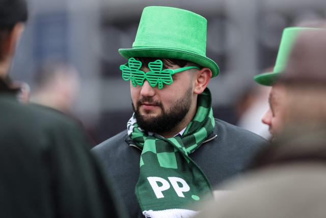 A racegoers marks 'St Patrick's Thursday' with an Irish them, on the third day of the Cheltenham Festival at Cheltenham Racecourse, in Cheltenham, western England on March 12, 2026. (Photo by Adrian Dennis / AFP)