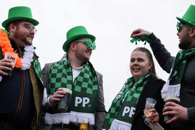 Racegoers mark 'St Patrick's Thursday' with an Irish them, on the third day of the Cheltenham Festival at Cheltenham Racecourse, in Cheltenham, western England on March 12, 2026. (Photo by Adrian Dennis / AFP)