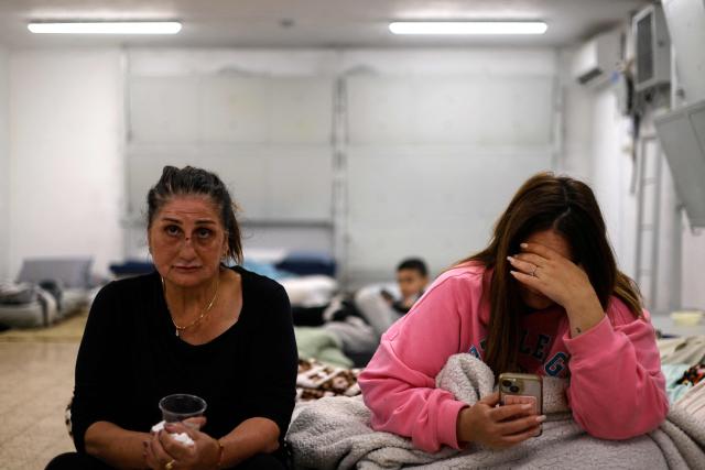 Israeli residents gather inside a shelter in Kiryat Shmona after a night of rockets fired from Lebanon on March 12, 2026. The Israeli military said that Hezbollah had fired around 200 rockets at Israel during the night, in what it described as the Lebanese armed group's "biggest barrage" since the war began. An Israeli strike on central Beirut's seafront killed eight people, Lebanon's health ministry said, as Israel threatened to expand operations and seize territory if Hezbollah does not stop its attacks. (Photo by Jalaa MAREY / AFP)