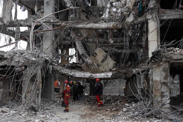Rescue workers stand amid the rubble of a destroyed residential building in Tehran on March 12, 2026. The United States and Israel started striking Iran on February 28, killing the Iranian supreme leader and top military leaders, and prompting authorities to retaliate with strikes on Israel and across the Gulf. (Photo by AFP) / 