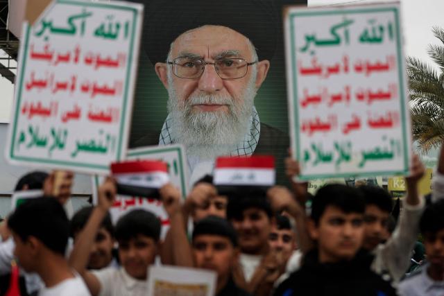 Schoolchildren display a poster of slain Iranian supreme leader Ayatollah Ali Khamenei during an anti-US and Israeli demonstration in Baghdad on March 12, 2026. Air strikes killed at least nine Iran-backed fighters in Iraq on March 12 near the Iraqi-Syrian border, two senior security officials told AFP. The Middle East war, which was triggered on February 28 by American-Israeli attacks on Iran, is hampering the global economy's supply of oil and weakening production capacity. (Photo by AHMAD AL-RUBAYE / AFP)