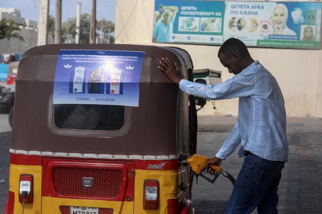 A tuk-tuk driver refuels his vehicle at a fuel station in Mogadishu on March 12, 2026. Petrol prices have doubled in Mogadishu from around $0.60 to $1.25 since the United States and Israel launched air strikes on Iran on February 28. 
Like many oil-importing countries, Somalia is feeling the effects of surging global oil prices as Iran's retaliatory strikes have targeted its Gulf neighbours and shipping through the vital Strait of Hormuz. (Photo by Hassan Ali ELMI / AFP)