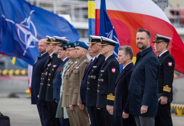 Poland's Deputy Prime Minister and Defence Minister Wladyslaw Kosiniak-Kamysz (2ndR) and Sweden's Defence Minister Pal Jonson (3rdR)  attend a welcoming ceremony in Polish Navy base in Gdynia on March 12, 2026. (Photo by Wojtek RADWANSKI / AFP)