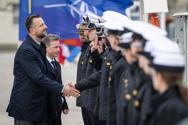 Poland's Deputy Prime Minister and Defence Minister Wladyslaw Kosiniak-Kamysz (L) and Sweden's Defence Minister Pal Jonson (2ndL) greet soldiers during a welcoming ceremony in Polish Navy base in Gdynia on March 12, 2026. (Photo by Wojtek RADWANSKI / AFP)