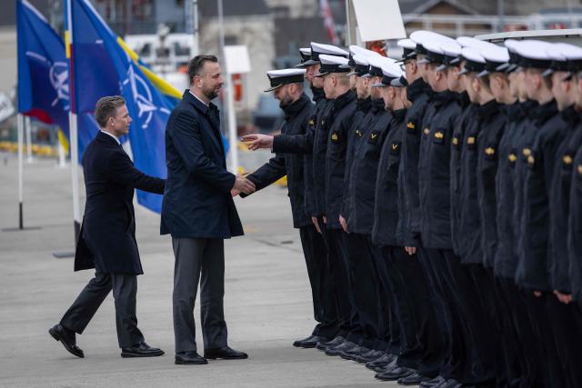 Poland's Deputy Prime Minister and Defence Minister Wladyslaw Kosiniak-Kamysz (2ndL) and Sweden's Defence Minister Pal Jonson (L) greet soldiers during a welcoming ceremony in Polish Navy base in Gdynia on March 12, 2026. (Photo by Wojtek RADWANSKI / AFP)