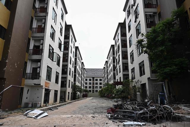 Damage sustained during fighting between Thailand and Cambodia is pictured on the outside of an abandoned scam centre in O'Smach town on the Thai-Cambodian border on March 12, 2026, during a press trip organised by Thailand's Ministry of Foreign Affairs and the Royal Thai Army. Broken computer monitors in bombed-out offices, scattered fake police uniforms, phony hundred dollar bills, Chinese tea tables: these were the vestiges of a frantic escape of suspected cyberscammers fleeing a resort on the Cambodia-Thailand border. (Photo by Lillian SUWANRUMPHA / AFP) / To go with 'THAILAND-CAMBODIA-CONFLICT-CYBERCRIME,FOCUS' by Chayanit ITTHIPONGMAETEE and Sally JENSEN
