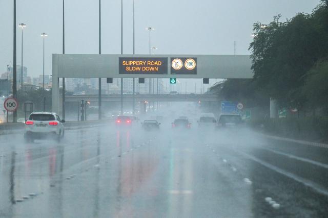 An announcement asks vehicles to slow down as they drive along a highway during a heavy rain in Kuwait City on March 12, 2026. (Photo by YASSER AL-ZAYYAT / AFP)