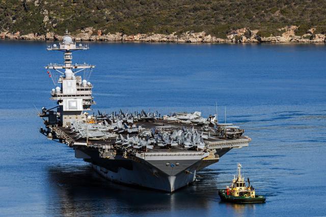 (FILES) The US Navy aircraft carrier USS Gerald R. Ford departs Souda Bay on the island of Crete on February 26, 2026. Two crew on the USS Gerald R. Ford -- the world's largest aircraft carrier currently deployed for the war against Iran -- were injured on March 12, 2026, in a laundry room fire, the US Navy said. "Two sailors are currently receiving medical treatment for non-life-threatening injuries and are in stable condition," a statement from US Naval Forces Central Command said. The Navy said the fire, originating "in the ship's main laundry," was "not combat-related and is contained." (Photo by Costas METAXAKIS / AFP)