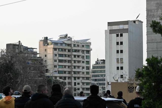 TOPSHOT - People watch an Israeli missile (top-R) hitting a building in the neighbourhood of Bashoura, central Beirut, on March 12, 2026. The Israeli military said it had begun a wave of strikes across Beirut on March 12, after it warned residents of a central neighbourhood of the Lebanese capital it would target a building there. (Photo by JOSEPH EID / AFP)