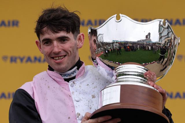 Jockey Darragh O'Keefe celebrates with the trophy after riding racehorse Heart Wood to win the Ryanair Chase (The Festival Trophy) horse race on the third day of the Cheltenham Festival at Cheltenham Racecourse, in Cheltenham, western England on March 12, 2026. (Photo by Adrian Dennis / AFP)