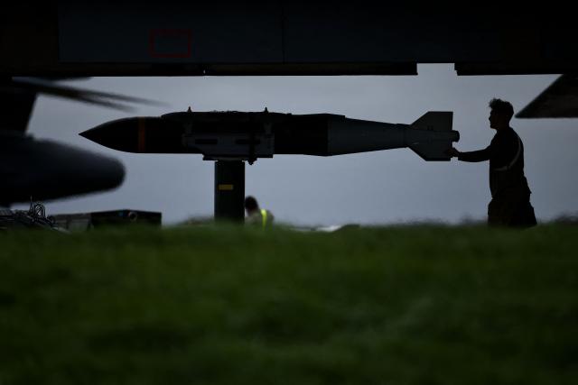 USAF military ground personnel prepare Joint Direct Attack Munitions (JDAM) for a US Air Force (USAF) B-1 Lancer bomber jet on the tarmac at RAF Fairford in south-west England on March 12, 2026. Fairford is one of two bases, along with the Diego Garcia facility in the Indian Ocean, that the UK has given the US permission to use for "specific defensive operations into Iran" to destroy Iranian missiles at source, the British defence minister said in a statement. (Photo by Henry NICHOLLS / AFP)